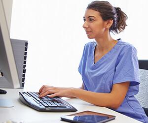 Medical Coder entering iinformation into patient system with a computer